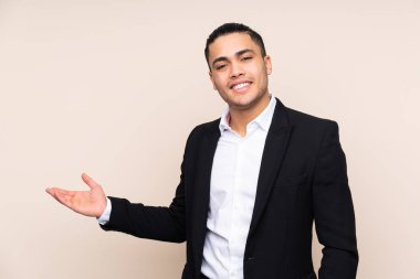 Asyalı iş adamı bej arka planda izole edilmiş.