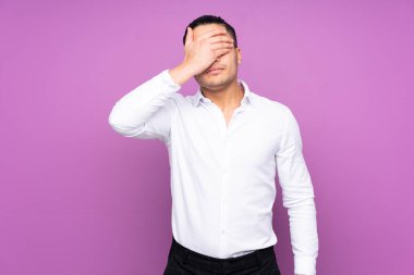 Asyalı yakışıklı bir adam mavi arka planda tek başına, gözleri elleriyle kapatıyor. Bir şey görmek istemiyorum.