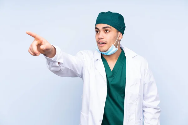 Chirurgo Uomo Con Uniforme Isolato Sfondo Blu Che Punta Lontano — Foto Stock