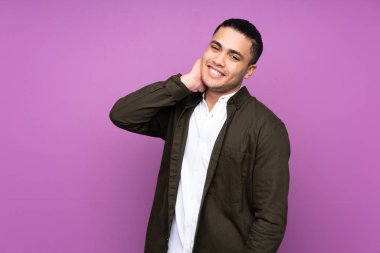 Asyalı yakışıklı adam mavi arka planda yalnız gülüyor.