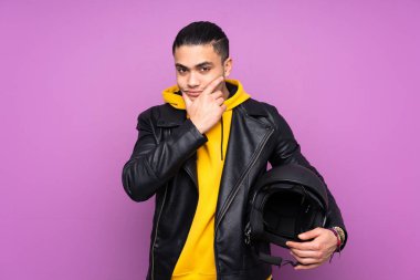 Motosiklet kasklı bir adam mor arka planda izole edilmiş bir fikir düşünüyor.