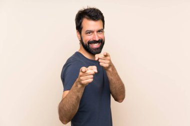 Sakallı bir adam kendine güvenen bir ifadeyle seni işaret ediyor.