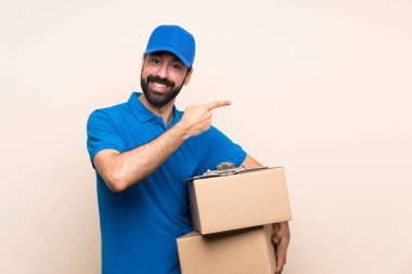 Delivery man with beard over isolated background pointing finger to the side clipart