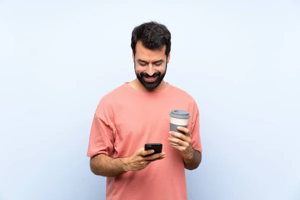 Joven Con Barba Sosteniendo Café Para Llevar Sobre Fondo Azul —  Fotos de Stock