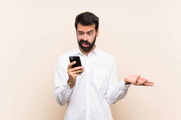 Young Man Beard Holding Mobile Making Doubts Gesture — Stock Photo, Image