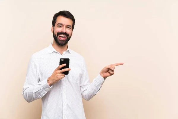 Junger Mann Mit Bart Hält Ein Handy Zur Seite Ein — Stockfoto