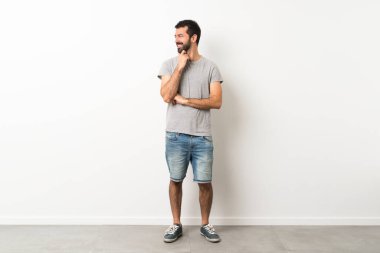 Sakallı yakışıklı bir adamın uzun bir resmi.