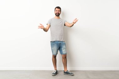 Sakallı, yakışıklı ve davetkar bir adamın uzun bir resmi.