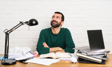 Öğrenci gülümserken yukarı bakıyor.