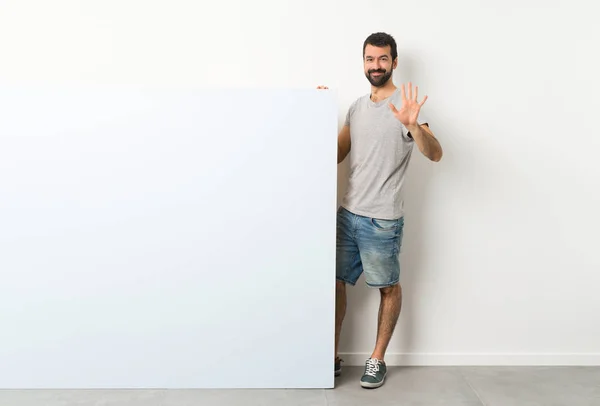 Jovem Homem Bonito Com Barba Segurando Grande Cartaz Azul Vazio — Fotografia de Stock