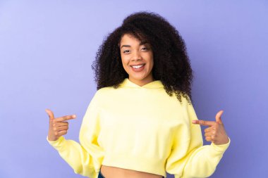 Genç Afrikalı Amerikalı kadın mor arka planda yalnız gururlu ve kendini beğenmiş.