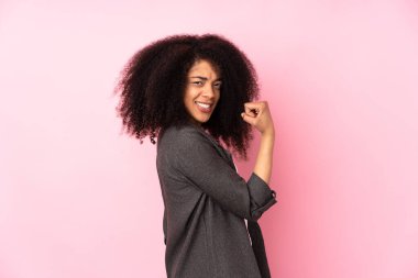 Genç Afrikalı Amerikalı kadın, izole edilmiş arka planda zaferi kutluyor.