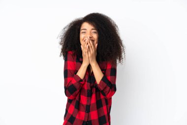 Genç Afro-Amerikalı kadın izole edilmiş arka planda mutlu ve gülümsüyor elleriyle ağzını kapatıyor.