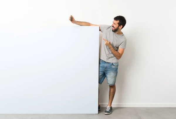 Jovem Homem Bonito Com Barba Segurando Grande Cartaz Azul Vazio — Fotografia de Stock