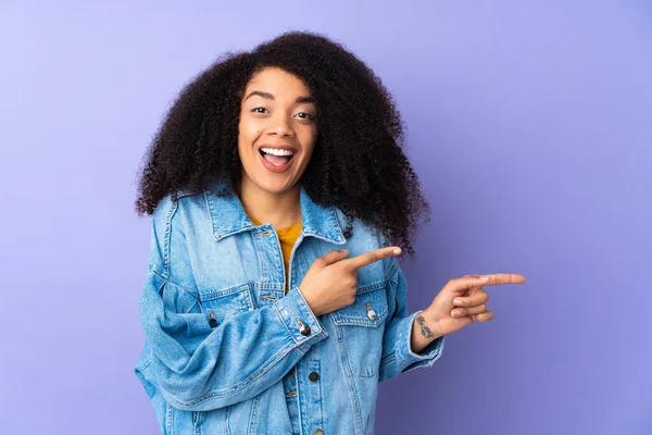 Jonge Afro Amerikaanse Vrouw Geïsoleerd Paarse Achtergrond Verrast Wijzen Kant — Stockfoto