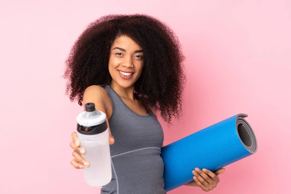 Joven Mujer Deportiva Afroamericana Aislada Sobre Fondo Rosa Con Botella —  Fotos de Stock