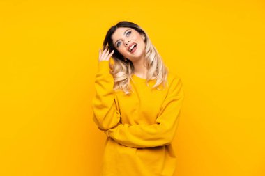 Genç kız sarı arka planda izole edilmiş bir fikir düşünüyor.