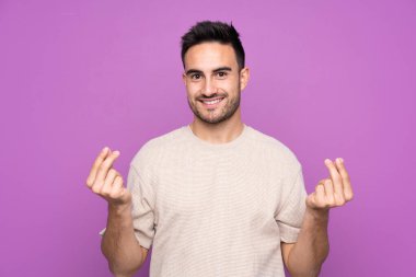 Soyutlanmış mor bir geçmişi olan yakışıklı genç adam para hareketi yapıyor.