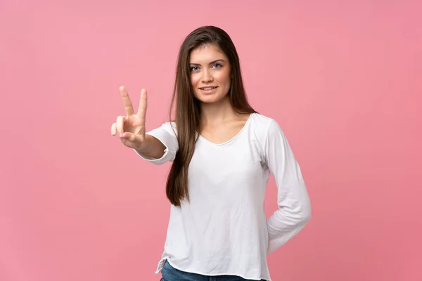 Junge Frau Vor Isoliertem Rosa Hintergrund Lächelt Und Zeigt Siegeszeichen — Stockfoto