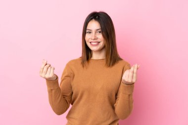 Soyutlanmış pembe bir geçmişi olan genç bir kadın para hareketi yapıyor.