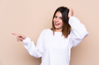 Izole arka plan üzerinde genç kadın şaşırttı ve yan parmak işaret