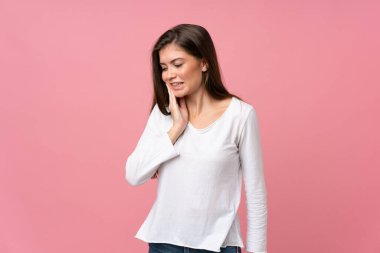 İzole edilmiş, pembe arka planda diş ağrısı olan genç bir kadın.