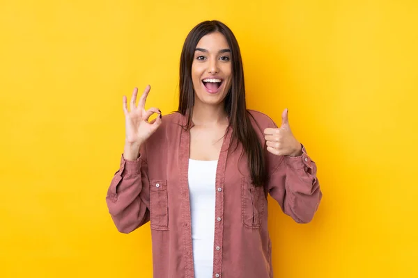 Joven Morena Mujer Sobre Aislado Amarillo Fondo Mostrando Signo Pulgar —  Fotos de Stock