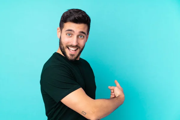 Caucásico Guapo Hombre Aislado Sobre Fondo Azul Apuntando Hacia Atrás —  Fotos de Stock