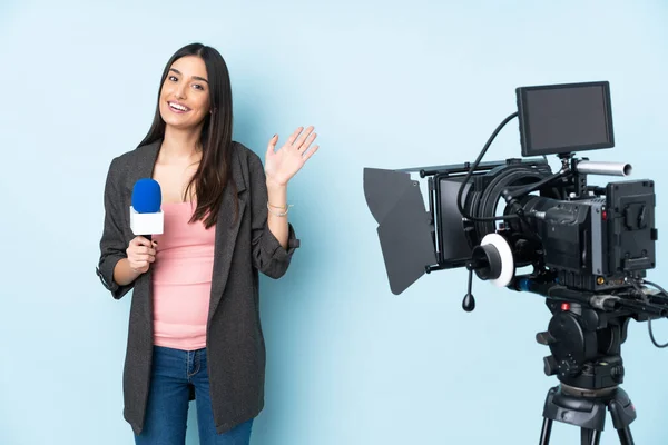 Mulher Repórter Segurando Microfone Reportando Notícias Isoladas Fundo Azul Saudando — Fotografia de Stock