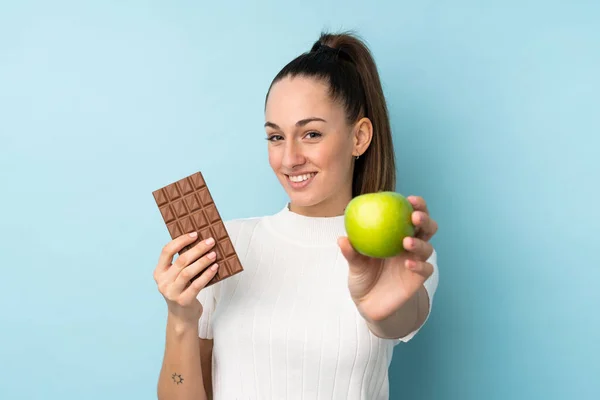 Fiatal Barna Izolált Kék Háttér Vesz Egy Csokoládé Tabletta Egyik — Stock Fotó