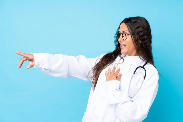 Junge Ärztin Über Isoliertem Blauem Hintergrund Zeigt Mit Dem Finger — Stockfoto