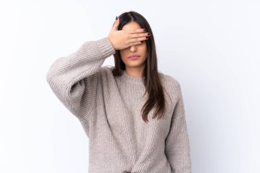 İzole edilmiş beyaz arka plan üzerindeki genç esmer kadın gözlerini elleriyle kapatıyor. Bir şey görmek istemiyorum.