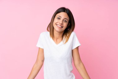Soyutlanmış pembe arka planda gülümseyen genç bir kadın