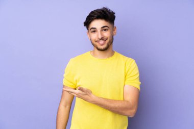 Münzevi bir geçmişi olan yakışıklı Arap bir adam gülümserken bir fikir sunuyor.