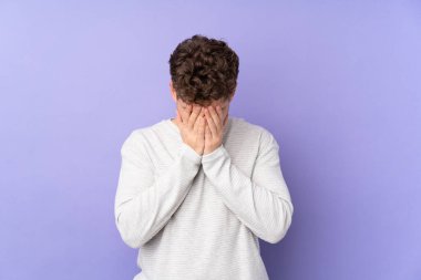 Beyaz adam mor arka planda izole edilmiş, yorgun ve hasta bir yüz ifadesi var.