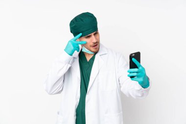 Yeşil üniformalı cerrah izole edilmiş beyaz arka planda selfie çekiyor.