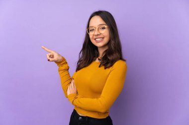 Mor arka planda izole edilmiş genç bir ırk kadını işaret ediyor.