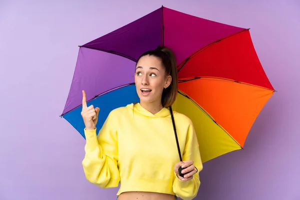 Junge Brünette Frau Hält Einen Regenschirm Über Isolierte Lila Wand — Stockfoto