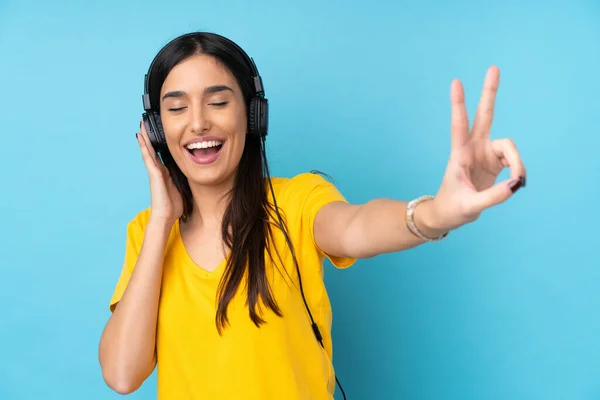 Joven Morena Sobre Fondo Azul Aislado Escuchando Música Cantando —  Fotos de Stock