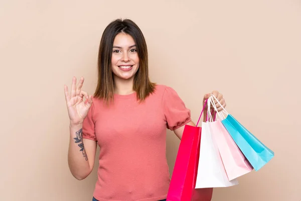 Mujer Joven Con Bolsa Compras Sobre Fondo Aislado Mostrando Signo —  Fotos de Stock