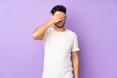 İzole edilmiş geçmişi olan yakışıklı Arap bir adam gözleri elleriyle kapatıyor. Bir şey görmek istemiyorum.