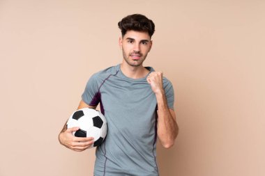 Futbol topunun zaferini kutlayan izole bir geçmişi olan genç bir adam.