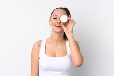 Genç esmer kadın ıssız beyaz arka planda nemlendirici ve mutlulukla