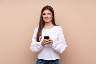Tecrit edilmiş genç bir kız cep telefonuyla mesaj gönderiyor.