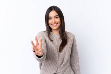 Genç esmer kadın izole edilmiş beyaz arka planda mutlu ve parmaklarıyla üçe kadar sayıyor.