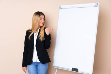 Genç Uruguaylı kadın beyaz tahtada bir sunum yapıyor.