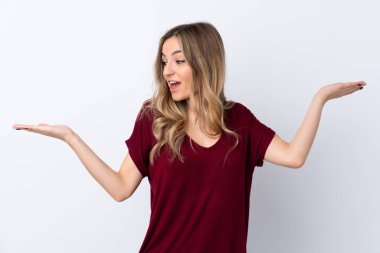 İzole edilmiş beyaz arka planı olan genç bir kadın iki eliyle kopyalama alanı tutuyor.