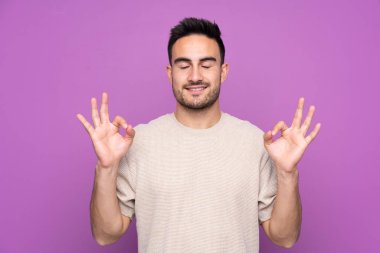 Zen pozisyonunda, soyutlanmış, mor bir geçmişi olan yakışıklı bir adam.