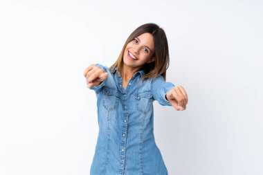 İzole edilmiş beyaz arka plandaki genç kadın gülümserken seni işaret ediyor.