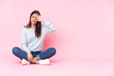 Pembe arka planda izole edilmiş, yorgun ve hasta bir yüzü olan beyaz bir kadın.